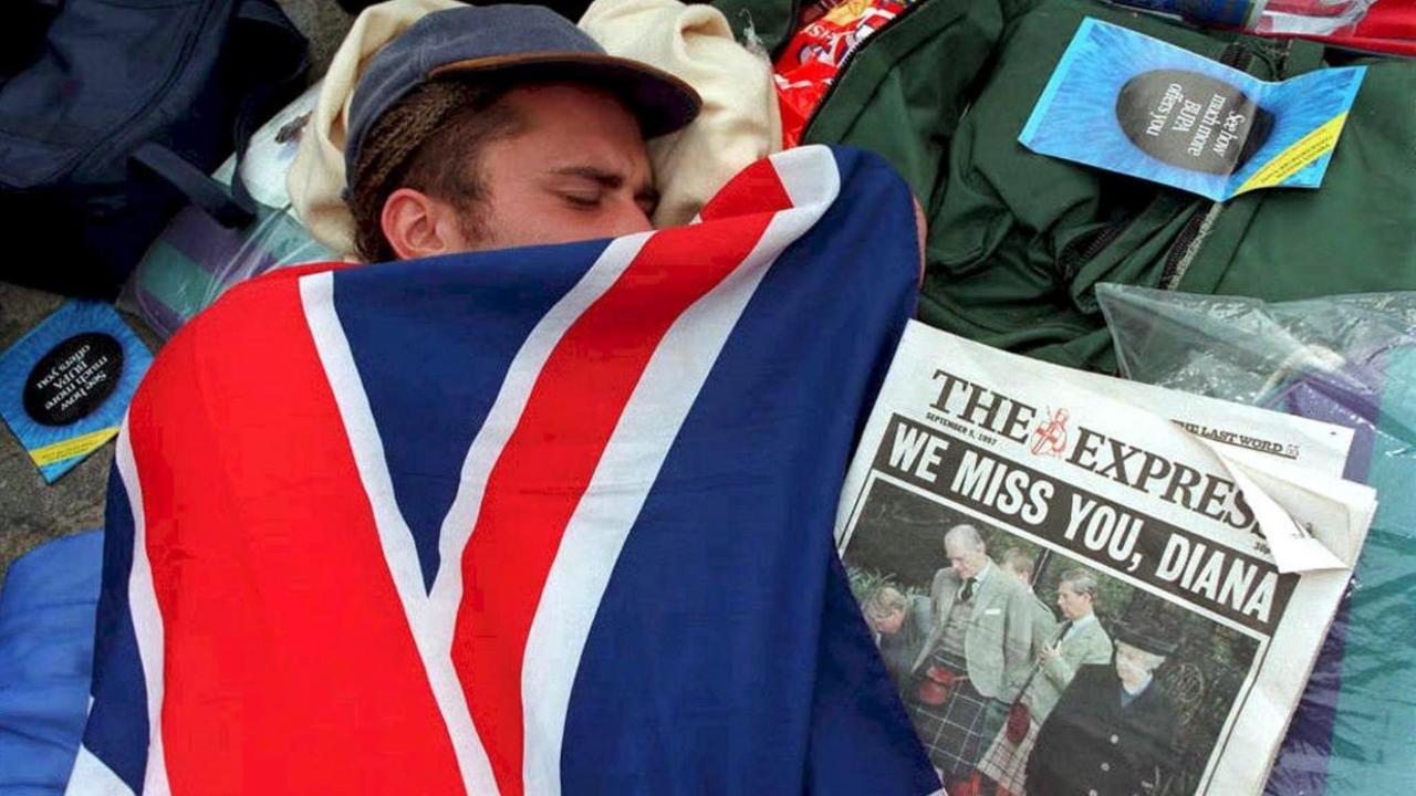 Eingehüllt in die britische Fahne schläft ein Trauernder vor der Westminster-Abtei in London. Bereits einen Tag vor der Trauerfeier für Prinzessin Diana kampierten in London rund 250 Menschen vor der Westminster-Abtei. Sie wollten sich einen günstigen Platz für die Feierlichkeiten sichern. Eingehüllt in die britische Fahne schläft ein Trauernder vor der Westminster-Abtei in London. Bereits einen Tag vor der Trauerfeier für Prinzessin Diana kampierten in London rund 250 Menschen vor der Westminster-Abtei. Sie wollten sich einen günstigen Platz für die Feierlichkeiten sichern.