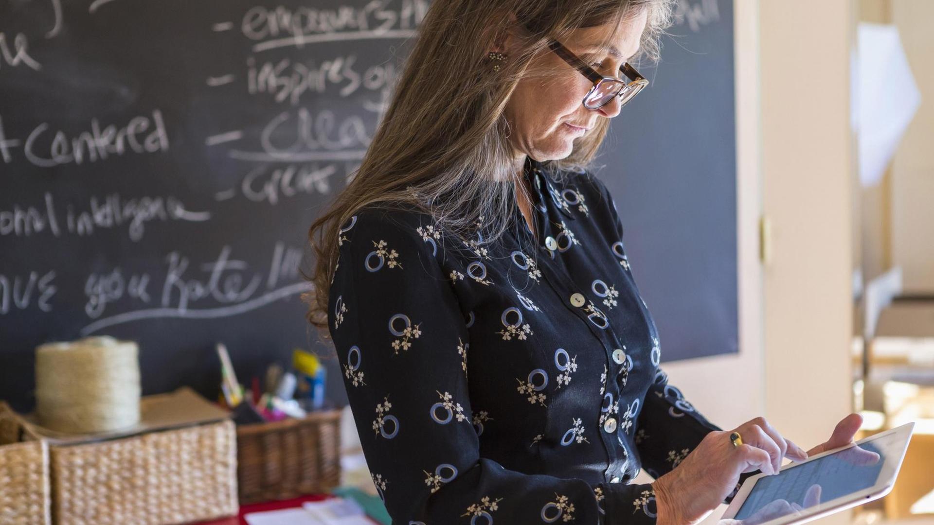 Lehrerin mit Tablet im Klassenzimmer Lehrerin mit Tablet im Klassenzimmer