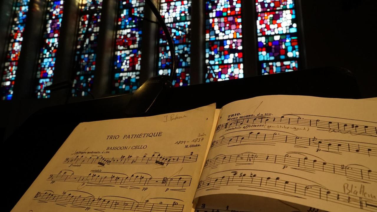 Aufgeschlagene Noten auf einem Pult vor den Kirchenfenstern. Aufgeschlagene Noten auf einem Pult vor den Kirchenfenstern.