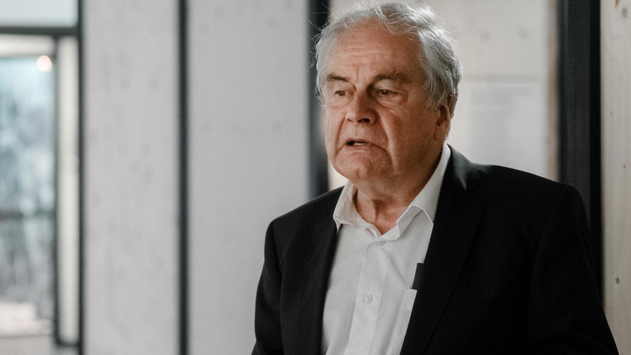 Frido Mann steht in nachdenklicher Pose in einem Gebäudeflur Frido Mann steht in nachdenklicher Pose in einem Gebäudeflur