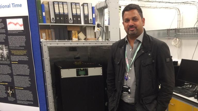 Leon Lobo vom National Physical Laboratory (NPL) in London vor einer Atomuhr Leon Lobo vom National Physical Laboratory (NPL) in London vor einer Atomuhr