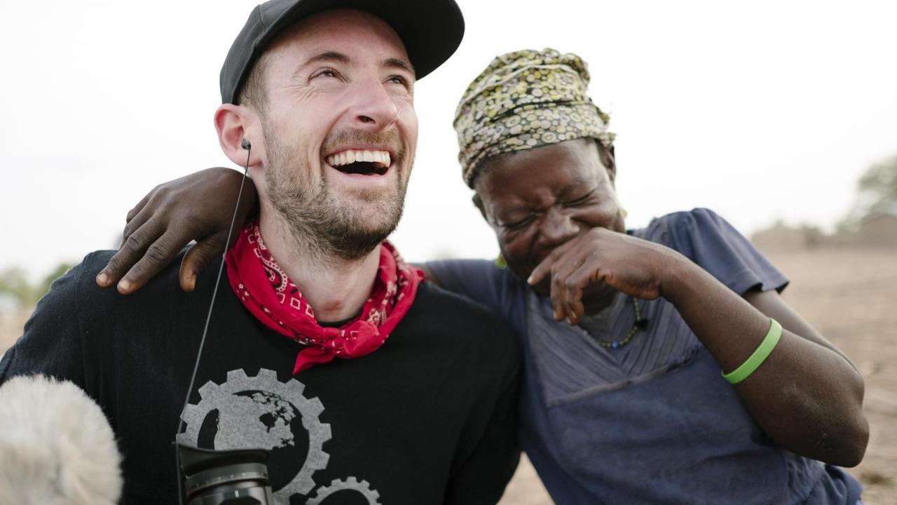 Bei der Dokumentation haben Mitarbeiter von Ecosia und Einheimische in Ghana zusammen Spaß. Bei der Dokumentation haben Mitarbeiter von Ecosia und Einheimische in Ghana zusammen Spaß.