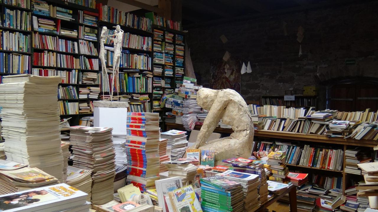 Skulpturen aus Romanseiten von Winfried Völlger fügen sich in das Meer aus Büchern ein Skulpturen aus Romanseiten von Winfried Völlger fügen sich in das Meer aus Büchern ein