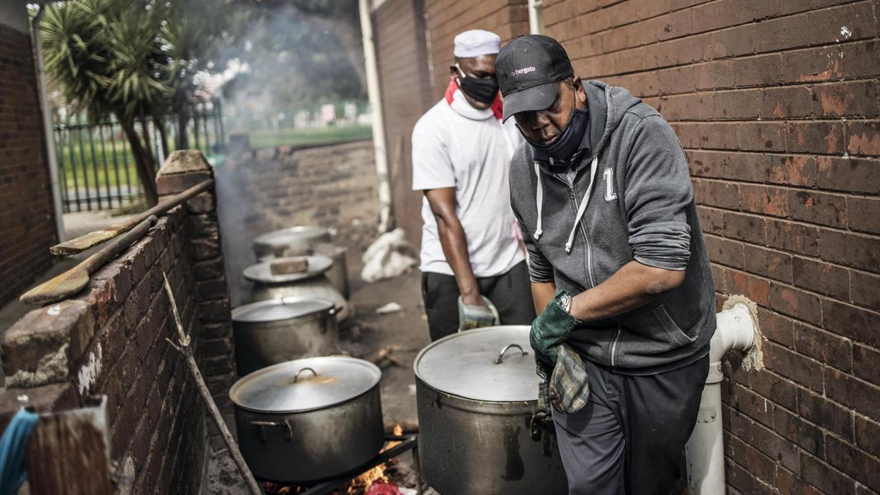 Charity-Mitarbeiter an einer Essensausgabe im südafrikanischen Johannesburg