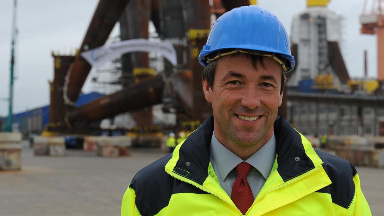Der SPD-Bundestagsabgeordnete Joahann Saathoff steht mit blauem Helm und gelber Jacke auf dem Werftgelände der Nordseewerke in Emden (Niedersachsen). Der SPD-Bundestagsabgeordnete Joahann Saathoff steht mit blauem Helm und gelber Jacke auf dem Werftgelände der Nordseewerke in Emden (Niedersachsen).