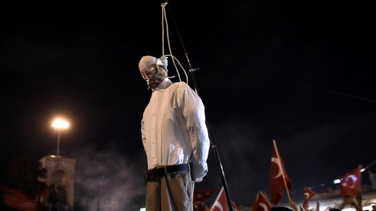 Anhänger des türkischen Präsidenten Erdogan halten eine Puppe, die den islamischen Prediger Fethullah Gülen darstellen soll, an einem Strick in die Höhe.