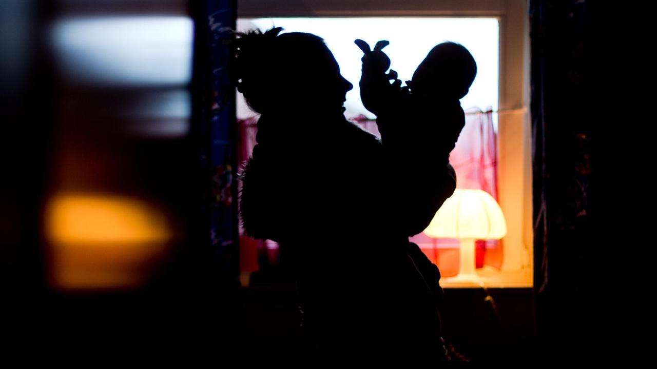 Die Silhouette einer Mutter, die mit ihrem Baby spielt. Die Silhouette einer Mutter, die mit ihrem Baby spielt.