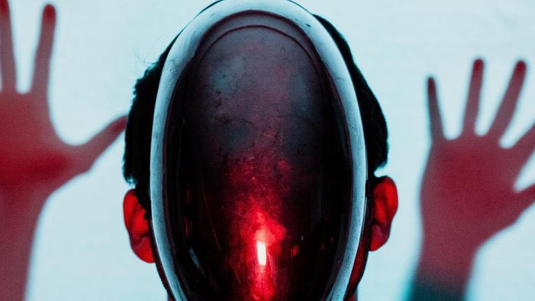 Ein Mensch mit einer spiegelnden Maske vor dem Gesicht. Er wirkt wie ein Roboter. Ein Mensch mit einer spiegelnden Maske vor dem Gesicht. Er wirkt wie ein Roboter.