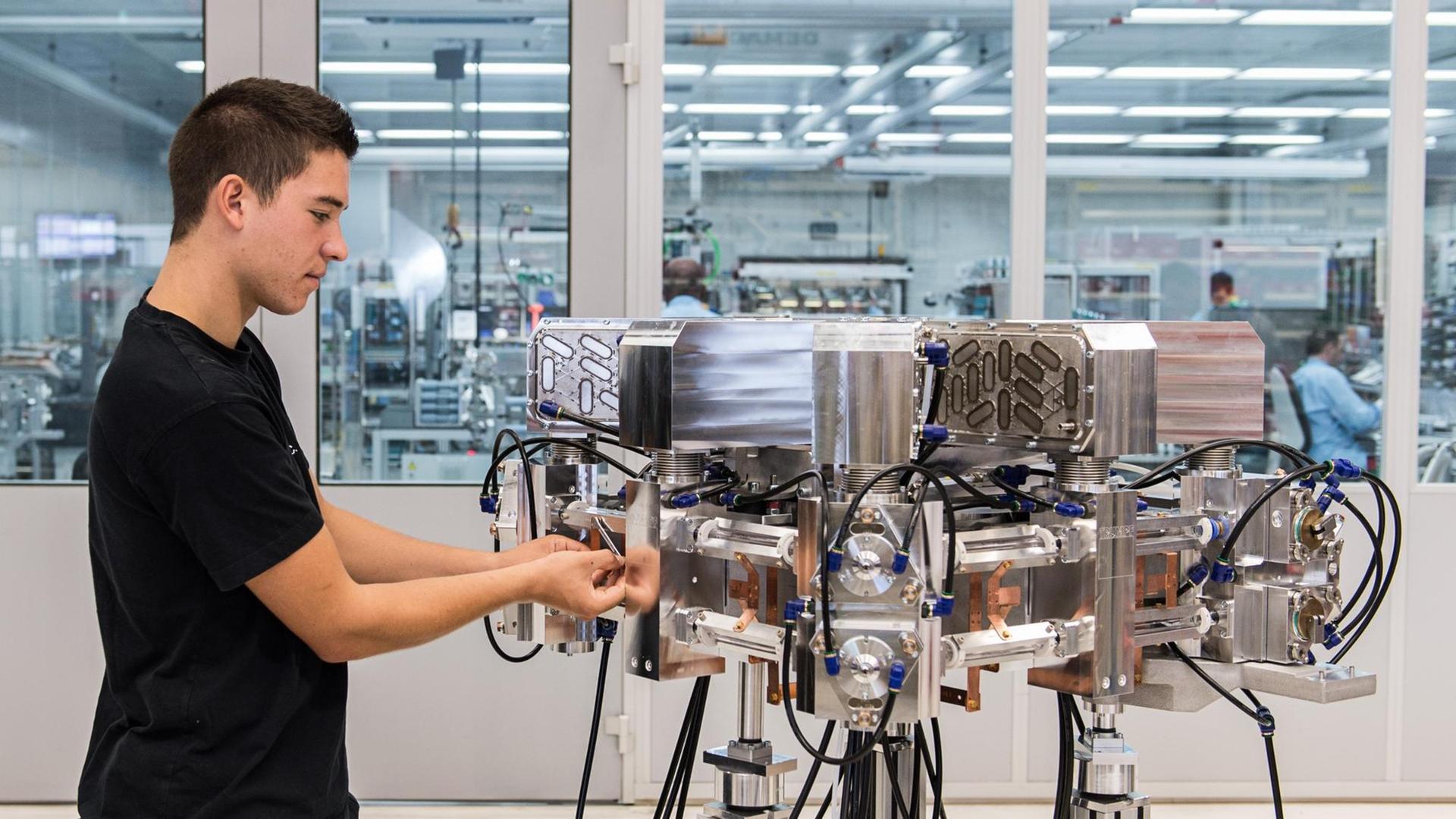 Ein Auszubildender Produktionstechnologe arbeitet am 19.08.2015 an einem Laserresonator.