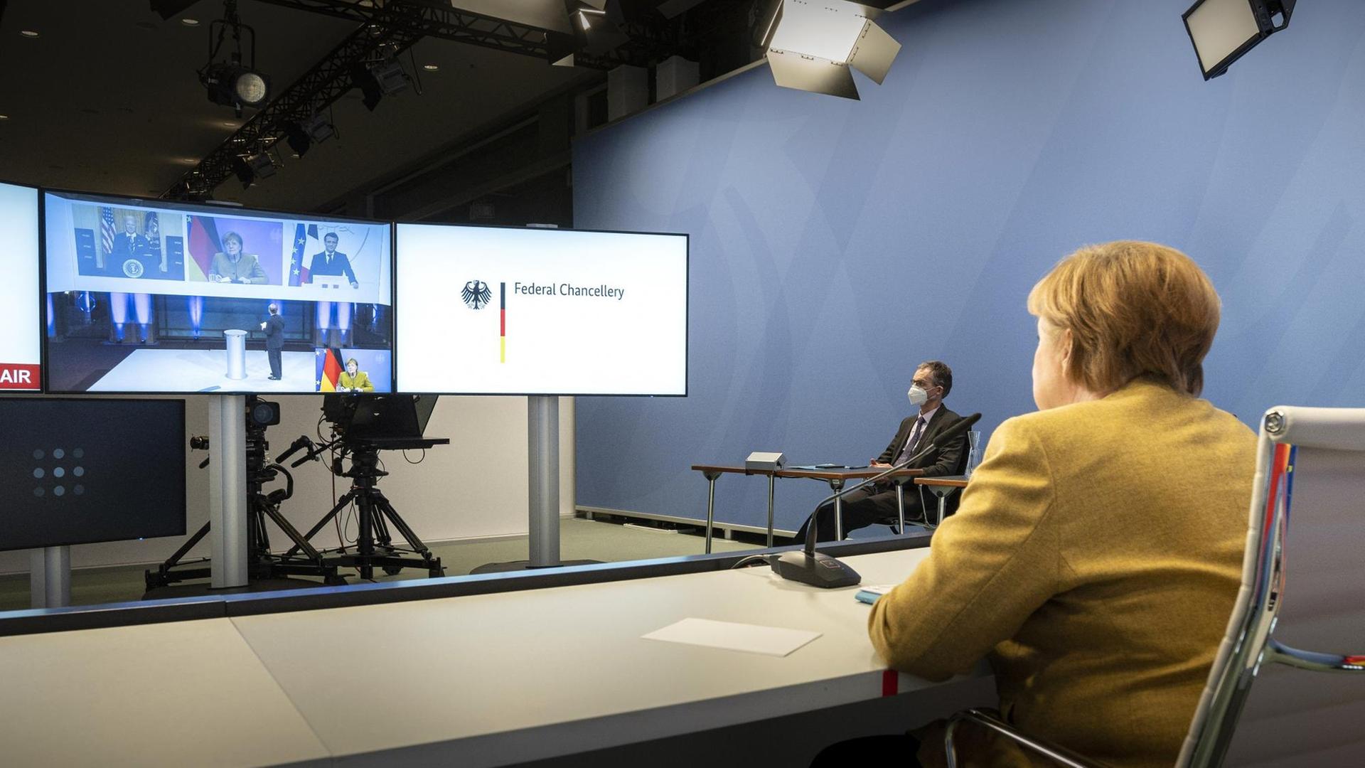 Bundeskanzlerin Angela Merkel (CDU) während einer Videokonferenz im Bundeskanzleramt im Rahmen der Münchner Sicherheitskonferenz mit US-Präsident Joe Biden und dem französischen Präsidenten Emmanuel Macron (auf dem Bildschirm)