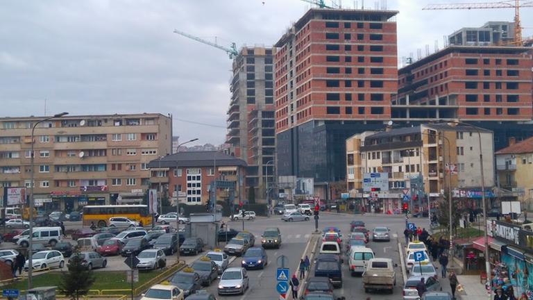 Hochhäuser am Rande Pristinas werden gebaut. Die Straße ist voll mit Autos. Hochhäuser am Rande Pristinas werden gebaut. Die Straße ist voll mit Autos.