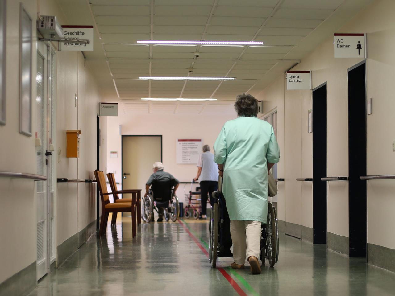 Heike Jakobi vom ehrenamtlichen Kranken-Lotsendienst schiebt einen Patienten zur Therapie im Albertinen-Haus in Hamburg. Heike Jakobi vom ehrenamtlichen Kranken-Lotsendienst schiebt einen Patienten zur Therapie im Albertinen-Haus in Hamburg.