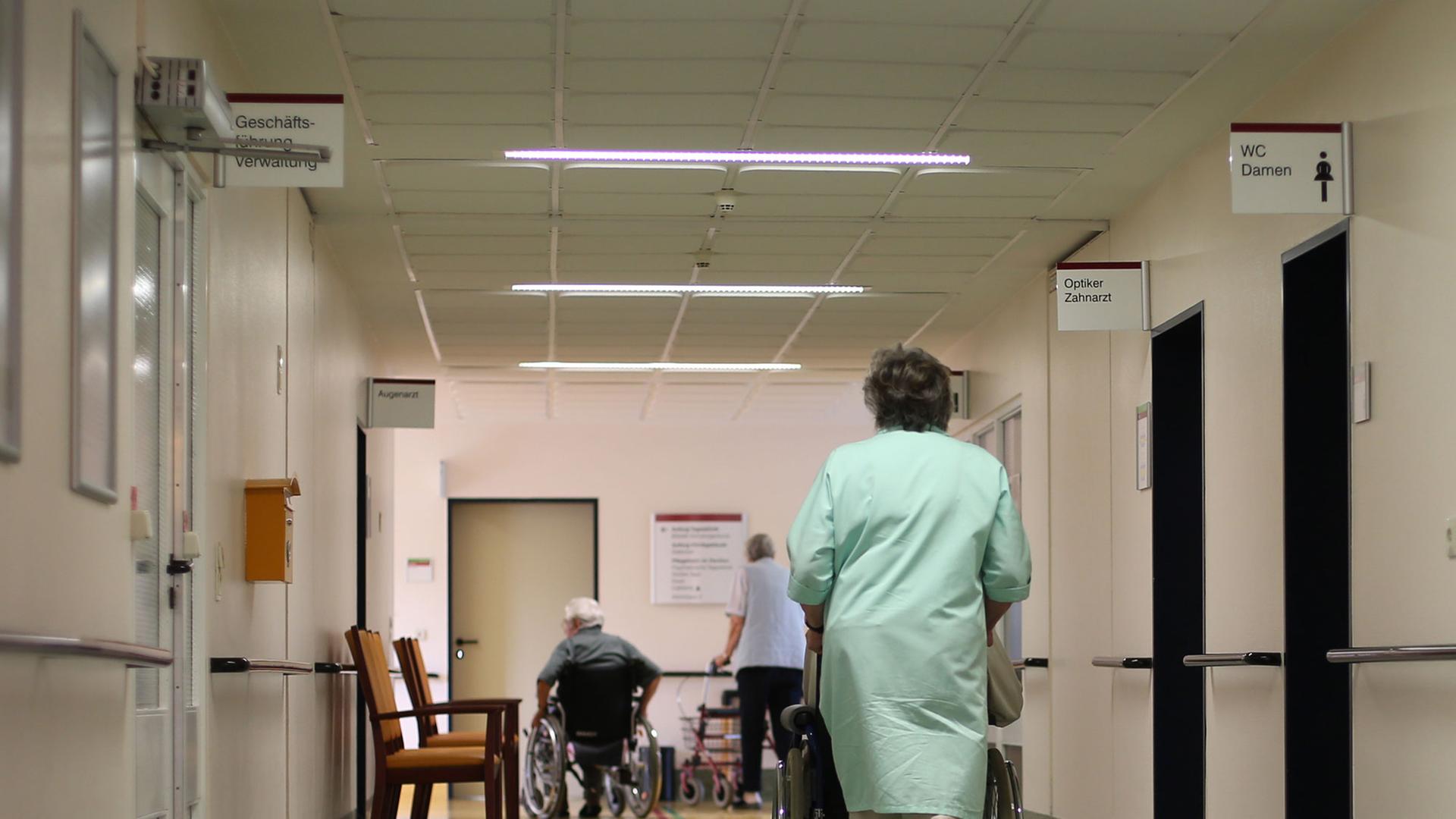 Heike Jakobi vom ehrenamtlichen Kranken-Lotsendienst schiebt einen Patienten zur Therapie im Albertinen-Haus in Hamburg. Heike Jakobi vom ehrenamtlichen Kranken-Lotsendienst schiebt einen Patienten zur Therapie im Albertinen-Haus in Hamburg.