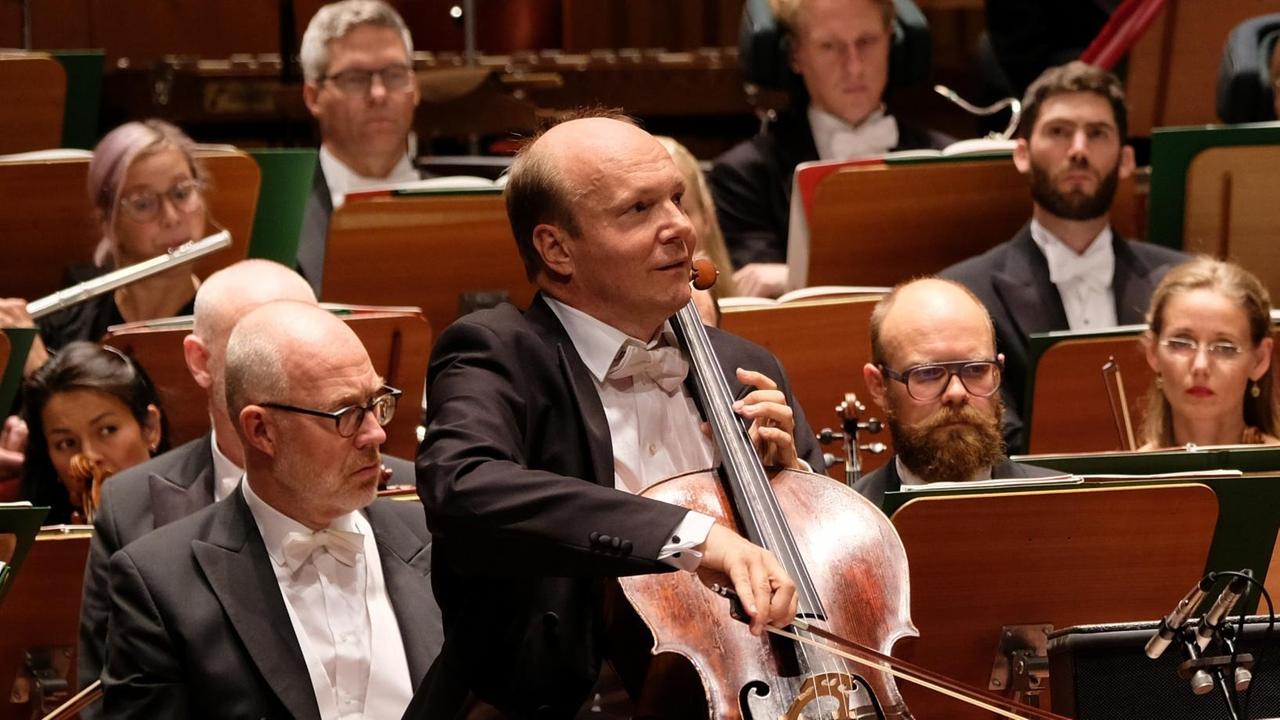 Der Cellist Truls Mørk sitzt vor dem Orchester und spielt. Der Cellist Truls Mørk sitzt vor dem Orchester und spielt.