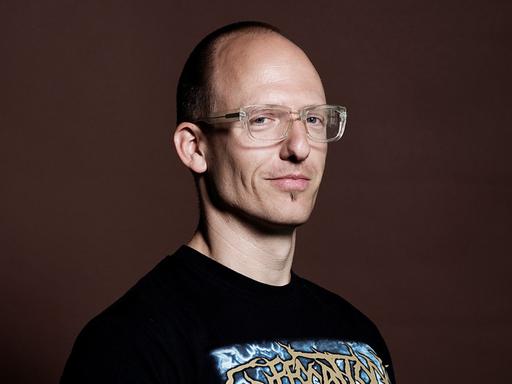 der Kunstwissenschaftler Jörg Scheller, im T-Shirt mit Brille
