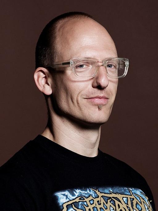 der Kunstwissenschaftler Jörg Scheller, im T-Shirt mit Brille