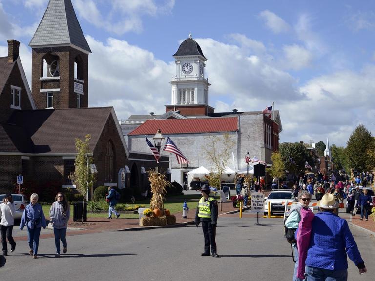 Stadtansicht: Straße, Kirche, Menschen spazieren.