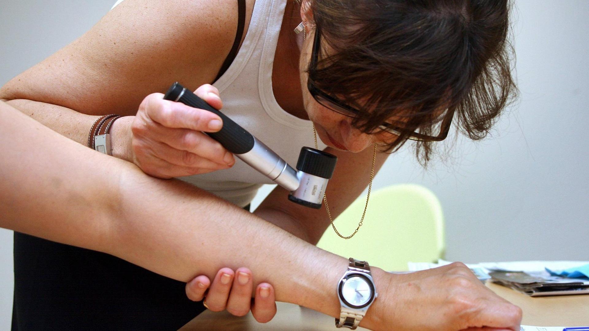 Hautärztin untersucht mit dem Dermatoskop die Haut eines Patienten. Hautärztin untersucht mit dem Dermatoskop die Haut eines Patienten.