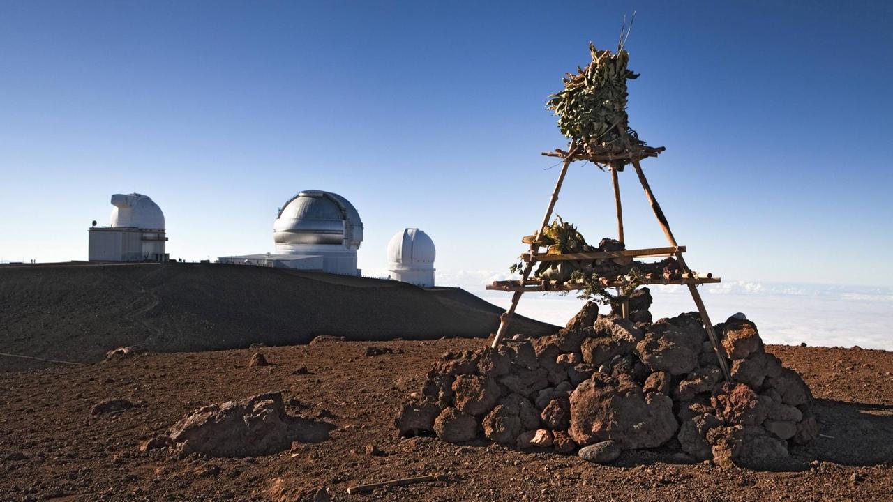 Prähistorische Götterwelt und moderne Wissenschaft: Ein traditioneller hawaiischer Tempel auf dem Gipfel des Vulkans Mauna Kea, im Hintergrund Teile des Mauna Kea-Observatoriums Prähistorische Götterwelt und moderne Wissenschaft: Ein traditioneller hawaiischer Tempel auf dem Gipfel des Vulkans Mauna Kea, im Hintergrund Teile des Mauna Kea-Observatoriums