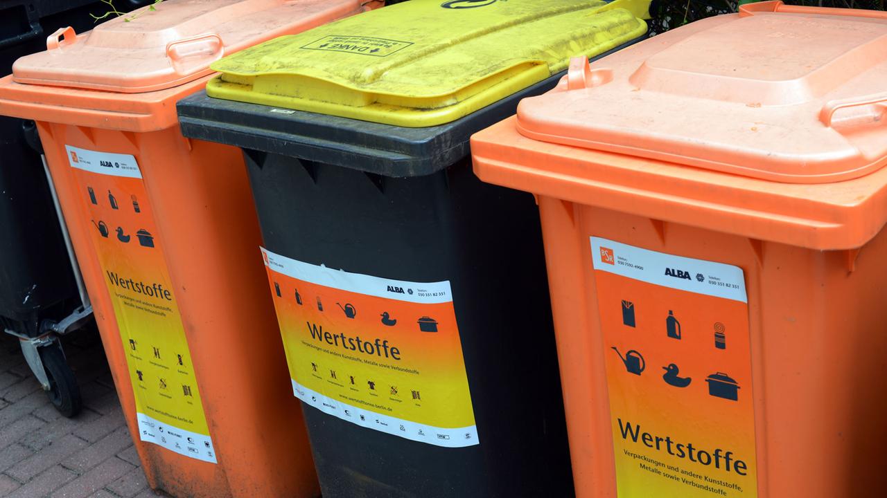 Drei Wertstofftonnen für Kunststoffe, Metall und Verbundmaterialien stehen nebeneinander. Drei Wertstofftonnen für Kunststoffe, Metall und Verbundmaterialien stehen nebeneinander.