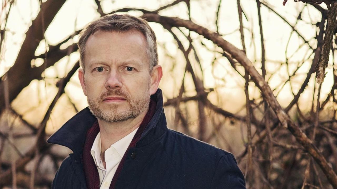 Adam Brookes posiert vor winterlich kahlen Bäumen. Adam Brookes posiert vor winterlich kahlen Bäumen.