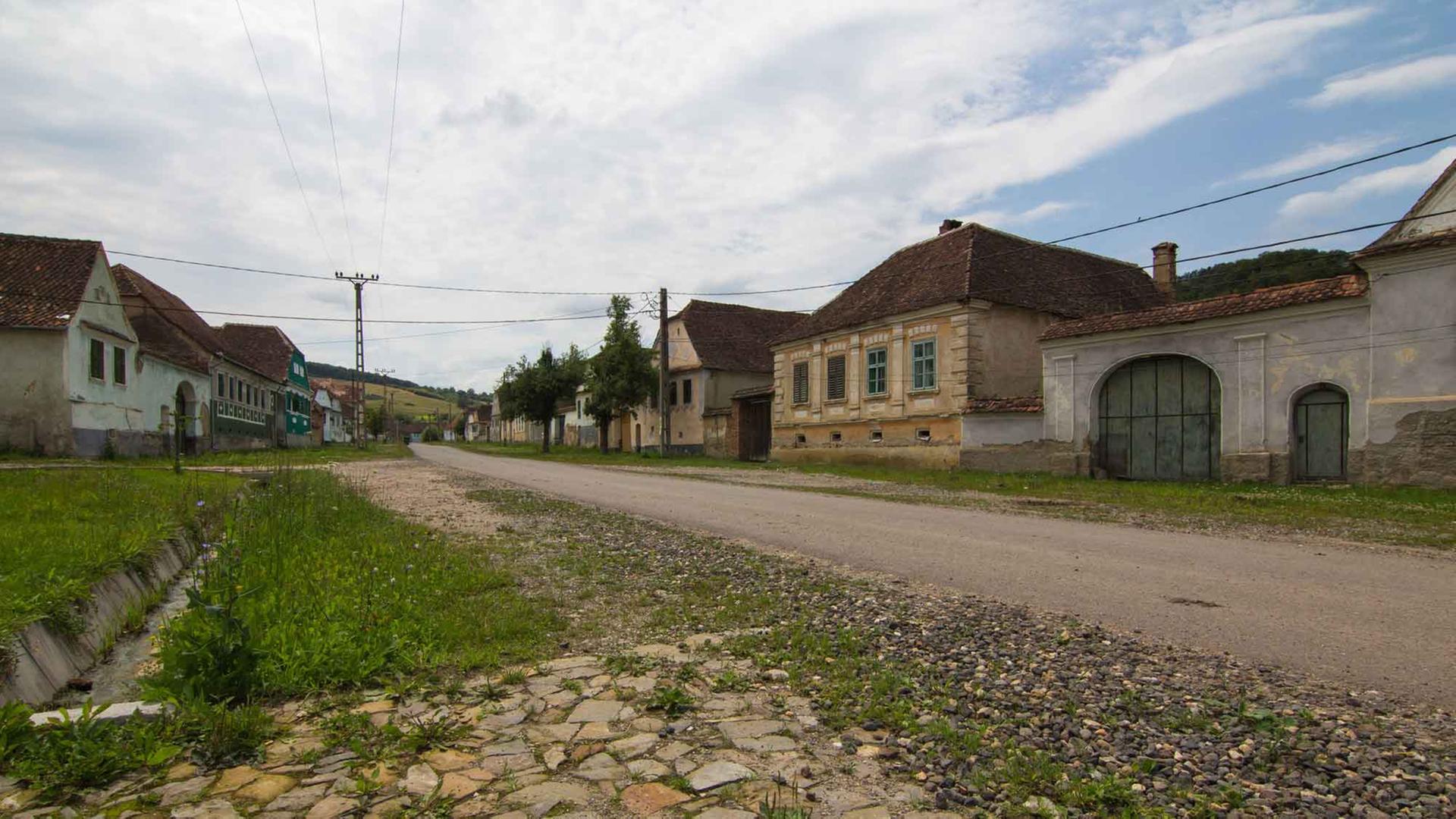 Ein typisches Dorf in Siebenbürgen, Rumänien, mit Dorfstraße und Steinhäusern. Ein typisches Dorf in Siebenbürgen, Rumänien, mit Dorfstraße und Steinhäusern.