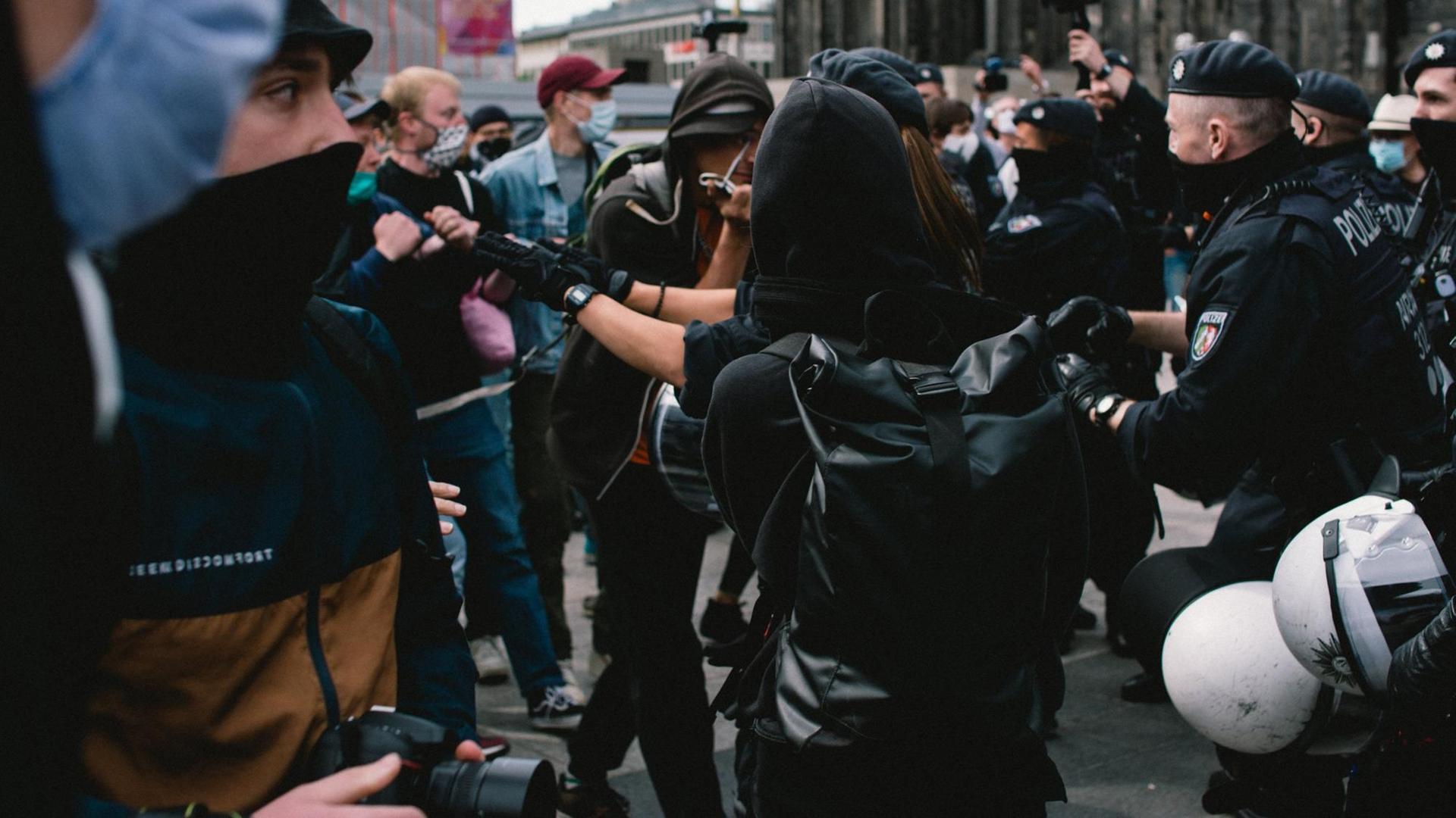 Auf dem Bild sind Demonstranten und Polizisten zu sehen. Sie stehen dicht gedrängt, die Szene wirkt bedrohlich. Auf dem Bild sind Demonstranten und Polizisten zu sehen. Sie stehen dicht gedrängt, die Szene wirkt bedrohlich.