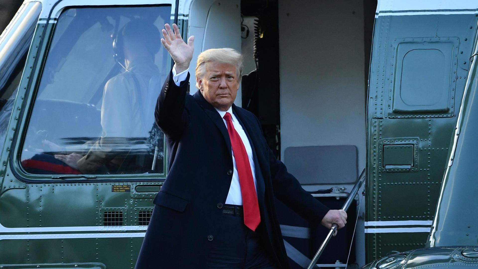 Donald Trump steht auf der Treppe eines Flugzeugs und winkt. Donald Trump steht auf der Treppe eines Flugzeugs und winkt.