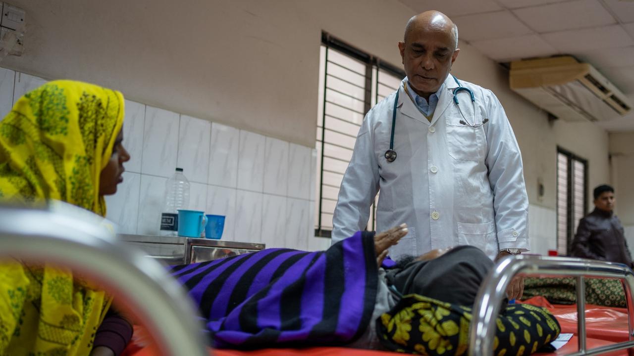Chefarzt Azharul Islam Khan im weißen Kittel spricht mit einer Cholerapatienten im Cholerakrankenhaus, International Centre for Diarrhoeal Disease Research, Bangladesh (icddr,b) Dhaka