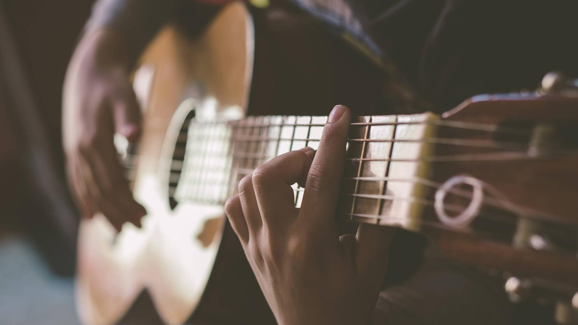 Ein Mann spielt auf einer Akustikgitarre. Ein Mann spielt auf einer Akustikgitarre.