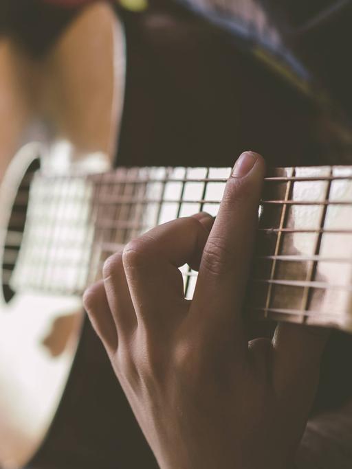 Ein Mann spielt auf einer Akustikgitarre.