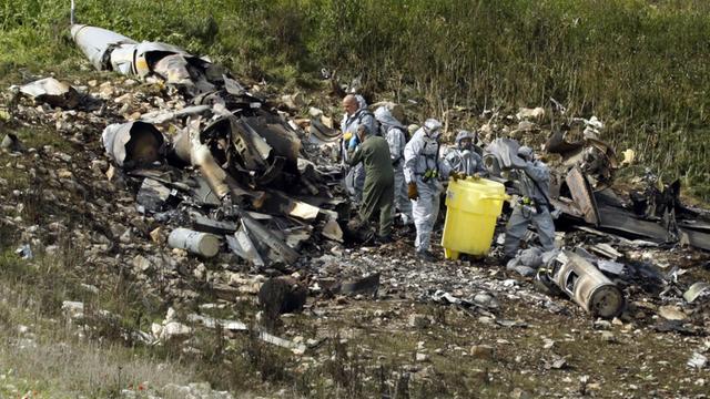 Israelische Sicherheitskräfte untersuchen die Überreste eines israelischen F-16 Kampfflugzeugs an der Absturzstelle bei Harduf.