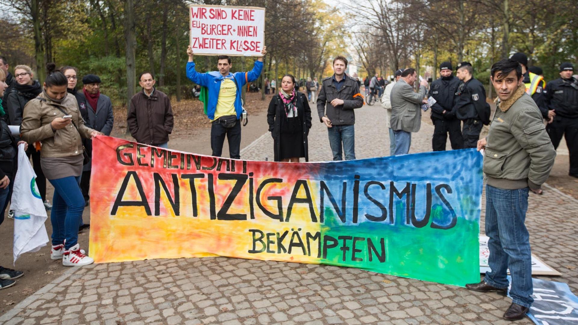 "Gemeinsam Antiziganismus bekämpfen" steht am 25.10.2013 vor dem Mahnmal für Sinti und Roma in Berlin bei einer Kundgebung auf einem Banner. "Gemeinsam Antiziganismus bekämpfen" steht am 25.10.2013 vor dem Mahnmal für Sinti und Roma in Berlin bei einer Kundgebung auf einem Banner.