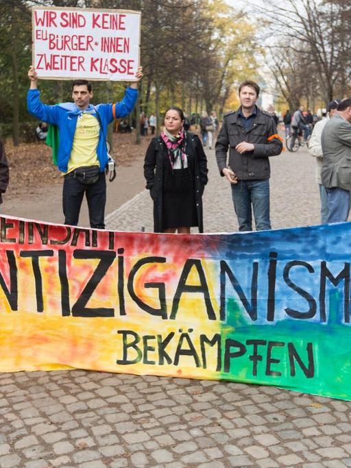 "Gemeinsam Antiziganismus bekämpfen" steht am 25.10.2013 vor dem Mahnmal für Sinti und Roma in Berlin bei einer Kundgebung auf einem Banner.