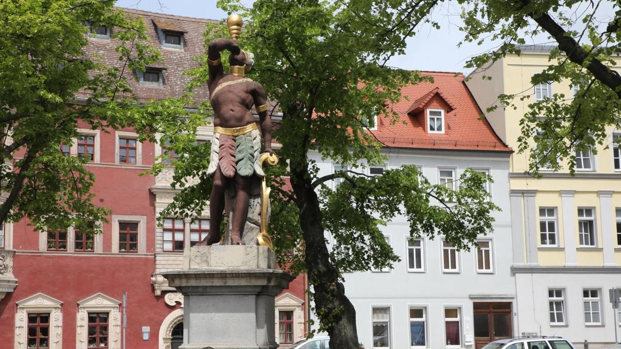 Der "Mohrenbrunnen" auf dem Marktplatz der thüringischen Stadt Eisenberg. Die Figur eines Schwarzen steht auf einem Podest in der Mitte des Brunnens. In Eisenberg findet am Wochenende das "Mohrenfest" statt. Der neue Name für das traditionelle Stadtfest sorgt in der Bevölkerung für Kritik. Der "Mohrenbrunnen" auf dem Marktplatz der thüringischen Stadt Eisenberg. Die Figur eines Schwarzen steht auf einem Podest in der Mitte des Brunnens. In Eisenberg findet am Wochenende das "Mohrenfest" statt. Der neue Name für das traditionelle Stadtfest sorgt in der Bevölkerung für Kritik.