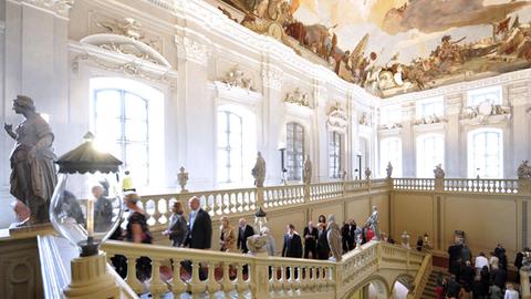 Im barocken Treppenhaus der Würzburger Residenz strömen Zuschauer zu einem Konzert.