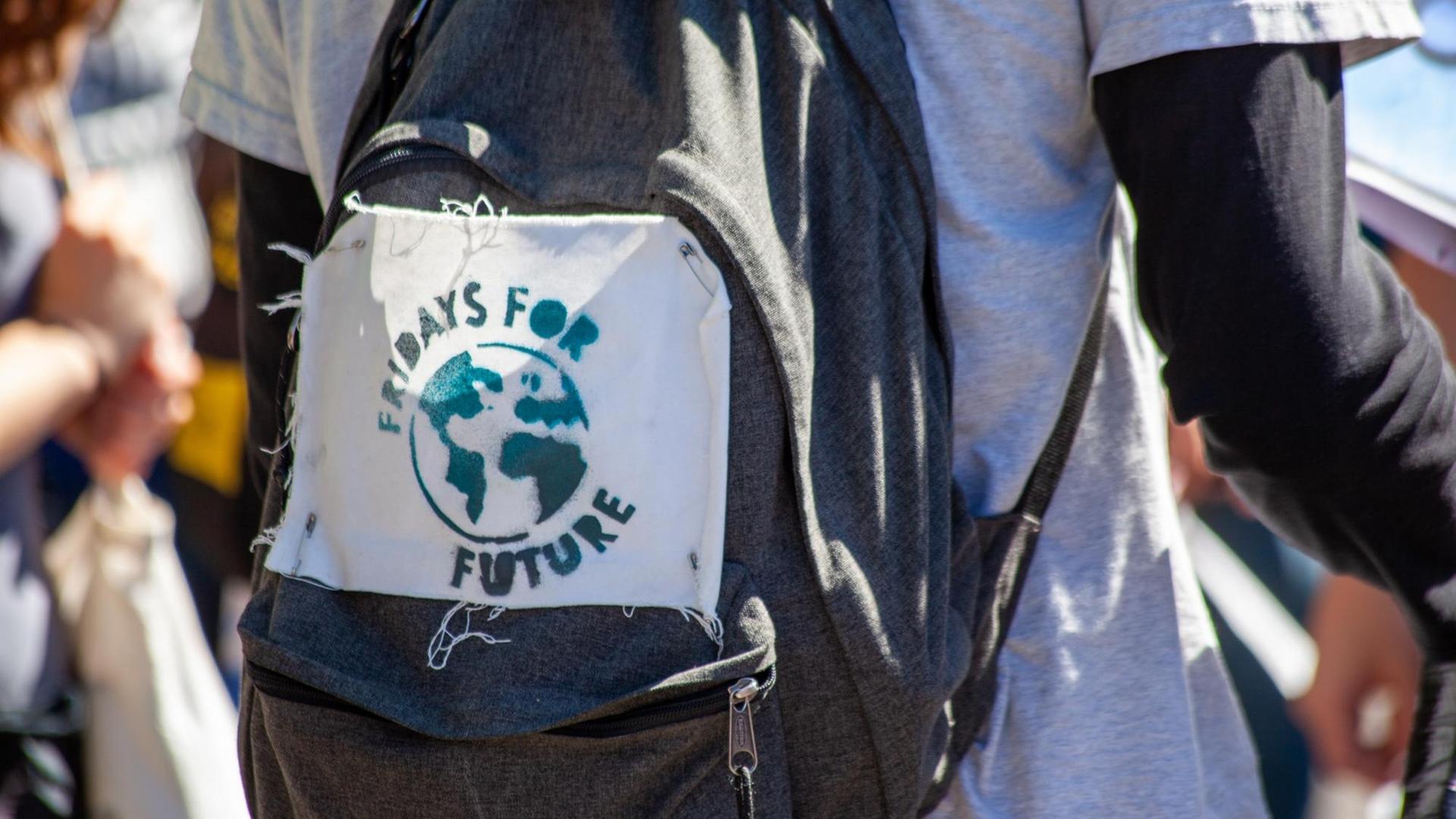 Auf einen Rucksack ist das handgemachte Logo von Fridays for Future gepinnt.