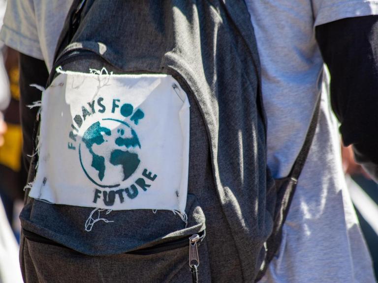 Auf einen Rucksack ist das handgemachte Logo von Fridays for Future gepinnt.