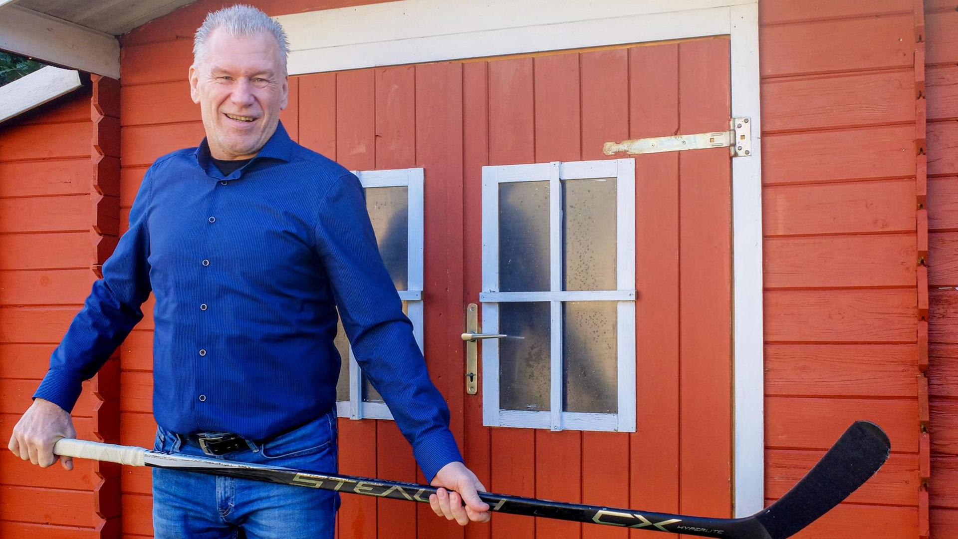 Der ehemalige deutsche Eishockey-Nationalspieler Manfred Wolf posiert mit einem Schläger in seinem Garten in Oberlungwitz bei Chemnitz. Der ehemalige deutsche Eishockey-Nationalspieler Manfred Wolf posiert mit einem Schläger in seinem Garten in Oberlungwitz bei Chemnitz.