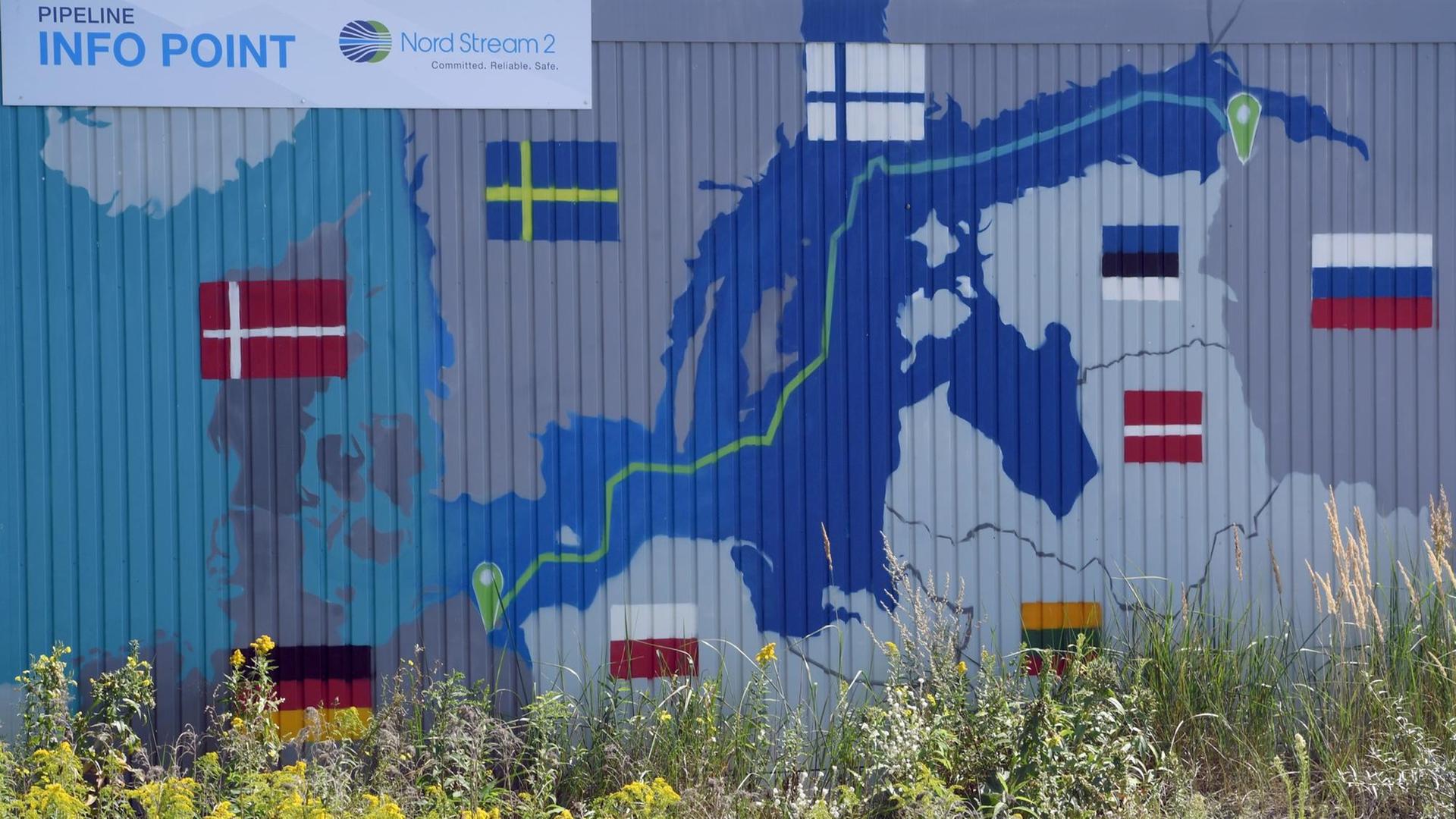Ein Schild mit der Aufschrift "Info Point Nord Stream 2 Committed Reliable Safe" hängt im Gewerbegebiet Lubmin über einer aufgemalten Landkarte an der Baustelle für die Empfangsstation. Ein Schild mit der Aufschrift "Info Point Nord Stream 2 Committed Reliable Safe" hängt im Gewerbegebiet Lubmin über einer aufgemalten Landkarte an der Baustelle für die Empfangsstation.