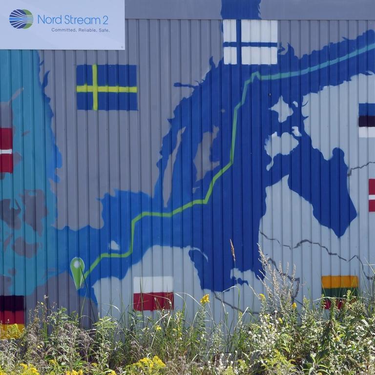 Ein Schild mit der Aufschrift "Info Point Nord Stream 2 Committed Reliable Safe" hängt im Gewerbegebiet Lubmin über einer aufgemalten Landkarte an der Baustelle für die Empfangsstation.