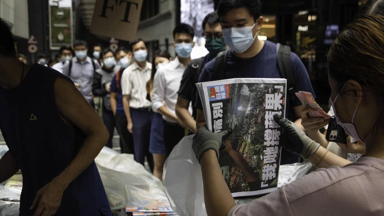 Beim Verkauf der letzten Ausgabe der Hongkonger Tageszeitung "Apple Daily" bildet sich eine lange Menschenschlange Beim Verkauf der letzten Ausgabe der Hongkonger Tageszeitung "Apple Daily" bildet sich eine lange Menschenschlange