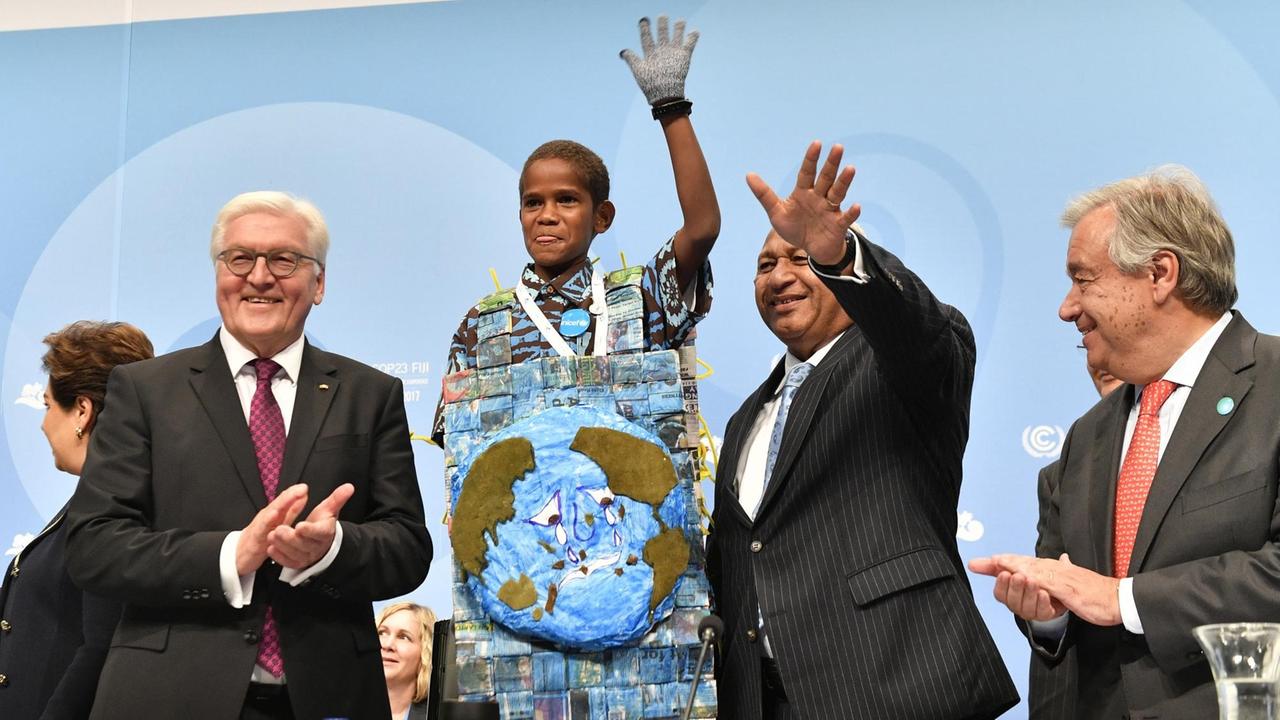 Frank-Walter Steinmeier (l.) und UNO-Generalsekretär Antonio Guterres (r.) auf der Klimakonferenz in Bonn. Mit im Bild: der Premierminister der Fidschi-Inseln, Frank Bainimarama, und Timoci Naulusala, ein Kind von den Fidschi-Inseln.