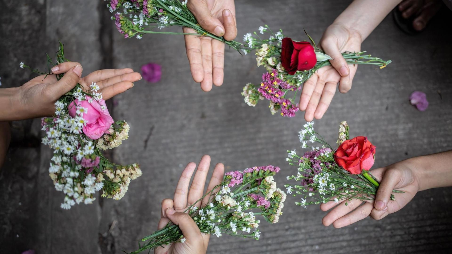 Fünf Hände mit dem Drei-Finger-Gruß, während sie Blumen zum Gedenken an die Opfer der gewaltsamen Proteste gegen die Machtübernahme des Militärs am 1. Februar halten. Menschen in Myanmar legten die Blumen an öffentlichen Plätzen zum Gedenken an die Opfer der gewaltsamen Proteste gegen die Machtübernahme des Militärs am 1. Februar nieder. Die Organisatoren riefen zu einem "Blumenstreik" auf und sagten, dass diese an Orten wie Parks und Bushaltestellen niedergelegt werden sollten, um der "Helden zu gedenken, die nicht mehr nach Hause zurückkehren können". Fünf Hände mit dem Drei-Finger-Gruß, während sie Blumen zum Gedenken an die Opfer der gewaltsamen Proteste gegen die Machtübernahme des Militärs am 1. Februar halten. Menschen in Myanmar legten die Blumen an öffentlichen Plätzen zum Gedenken an die Opfer der gewaltsamen Proteste gegen die Machtübernahme des Militärs am 1. Februar nieder. Die Organisatoren riefen zu einem "Blumenstreik" auf und sagten, dass diese an Orten wie Parks und Bushaltestellen niedergelegt werden sollten, um der "Helden zu gedenken, die nicht mehr nach Hause zurückkehren können".