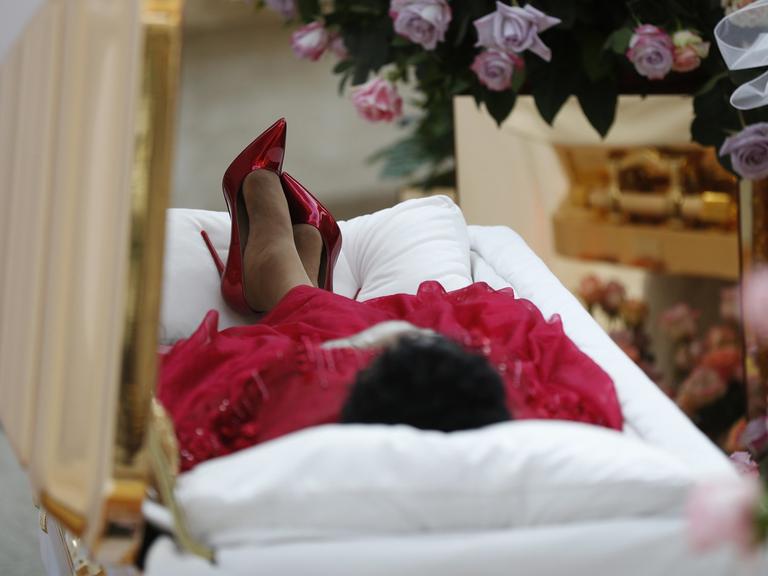Die verstorbene Soulsängerin Aretha Franklin liegt aufgebahrt in einem goldenen Sarg im Charles H. Wright Museum of African American History in Detroit. Sie trägt ein rotes Kleid und rote Pumps.