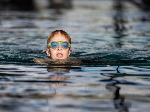 Ein Junge nimmt an einem Schwimmkurs für Kinder der DLRG im Monte Mare Schwimmbad in Bedburg (Nordrhein-Westfalen) teil.