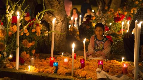 Menschen in Santa Maria Atzompa widmen am "Tag der Toten" den Verstorbenen Blumen, Getränke und Essen.