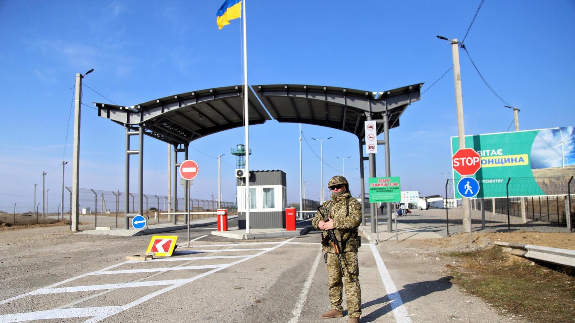 Ein bewaffneter Grenzschutzbeamter steht vor dem Kontrollpunkt Chonhar an der Verwaltungsgrenze zwischen der Region Kherson und der besetzten Krim am 15. November 2019. Ein bewaffneter Grenzschutzbeamter steht vor dem Kontrollpunkt Chonhar an der Verwaltungsgrenze zwischen der Region Kherson und der besetzten Krim am 15. November 2019.