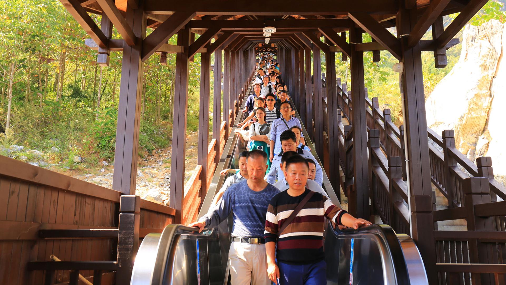 Touristen auf einer Rolltreppe im Enshi Grand Cancon in China Touristen auf einer Rolltreppe im Enshi Grand Cancon in China