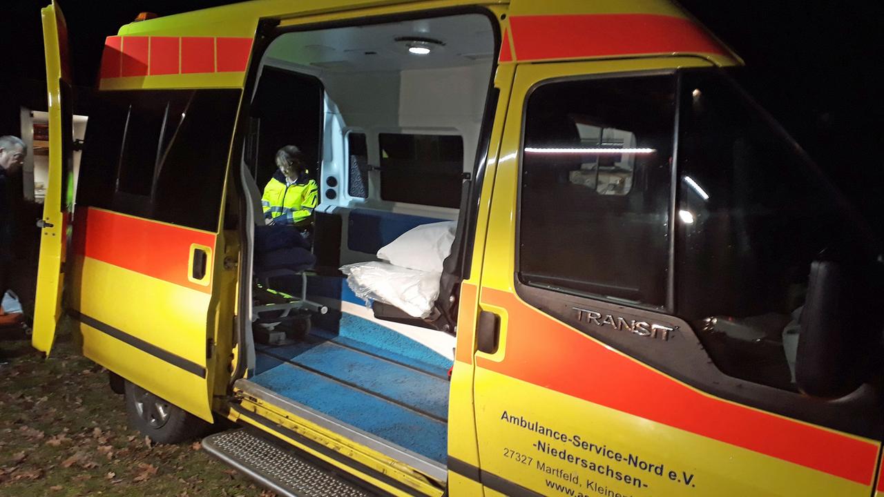 Blick in den umgebauten Krankenwagen des Ambulance-Service-Nord, im Hintergrund ein ehrenamtlicher Helfer in gelber Warnweste.